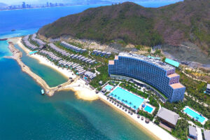 Toàn cảnh khu nghỉ dưỡng vinpearl nha trang bay nhìn từ trên cao với khách sạn, villa ven biển và hồ bơi sát bờ biển xanh trong.
