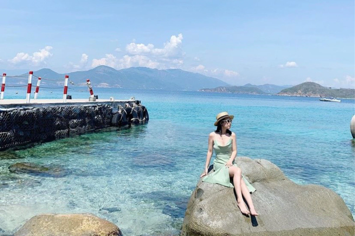 Du khách nghỉ chân bên bãi biển trong hành trình tour đảo Nha Trang dành cho gia đình có con nhỏ mùa nắng đẹp, tránh những sai lầm khi đi Nha Trang để chuyến đi trọn vẹn