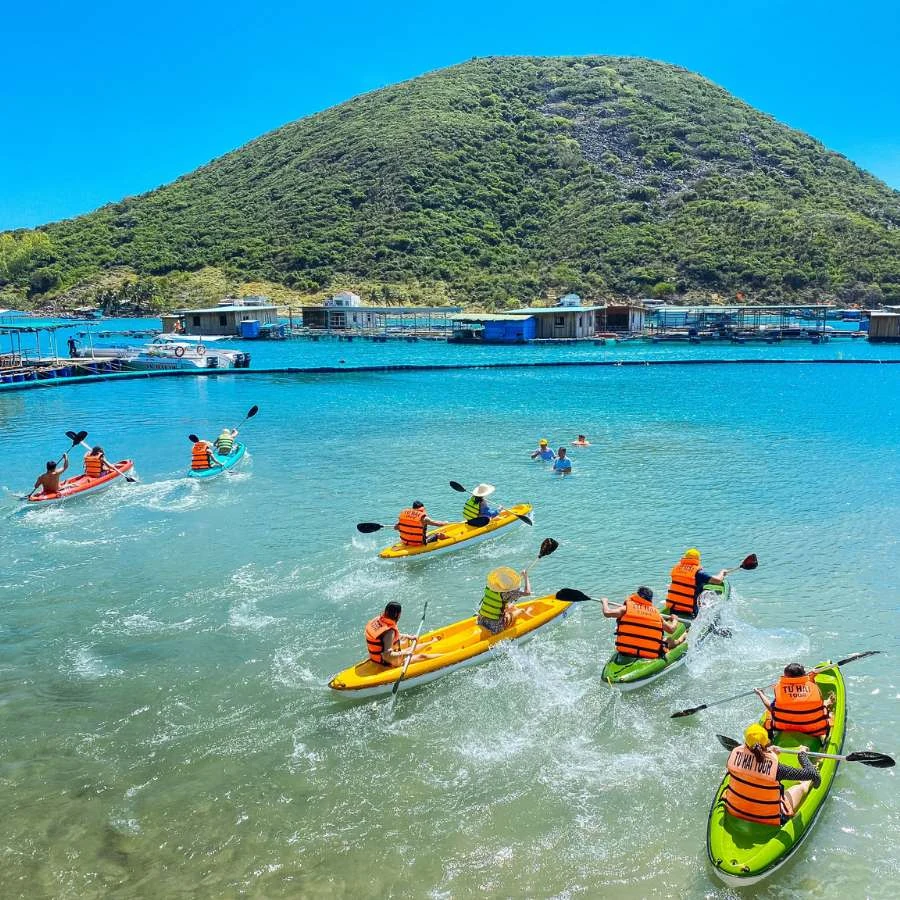 Du khách mặc áo phao chèo kayak nhiều màu gần đảo Robinson ở Nha Trang