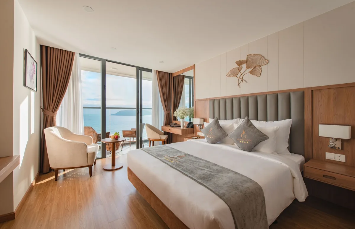 Phòng ngủ có cửa kính nhìn ra biển ở Grand Gosia Hotel Nha Trang