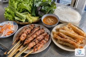Mâm nem nướng Nha Trang gồm nem nướng xiên que, bánh tráng chiên giòn, bánh tráng cuốn, rau sống, đồ chua và chén nước chấm, ảnh minh hoạ