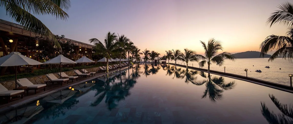 Hồ bơi sát biển của Amiana Resort Nha Trang lúc hoàng hôn